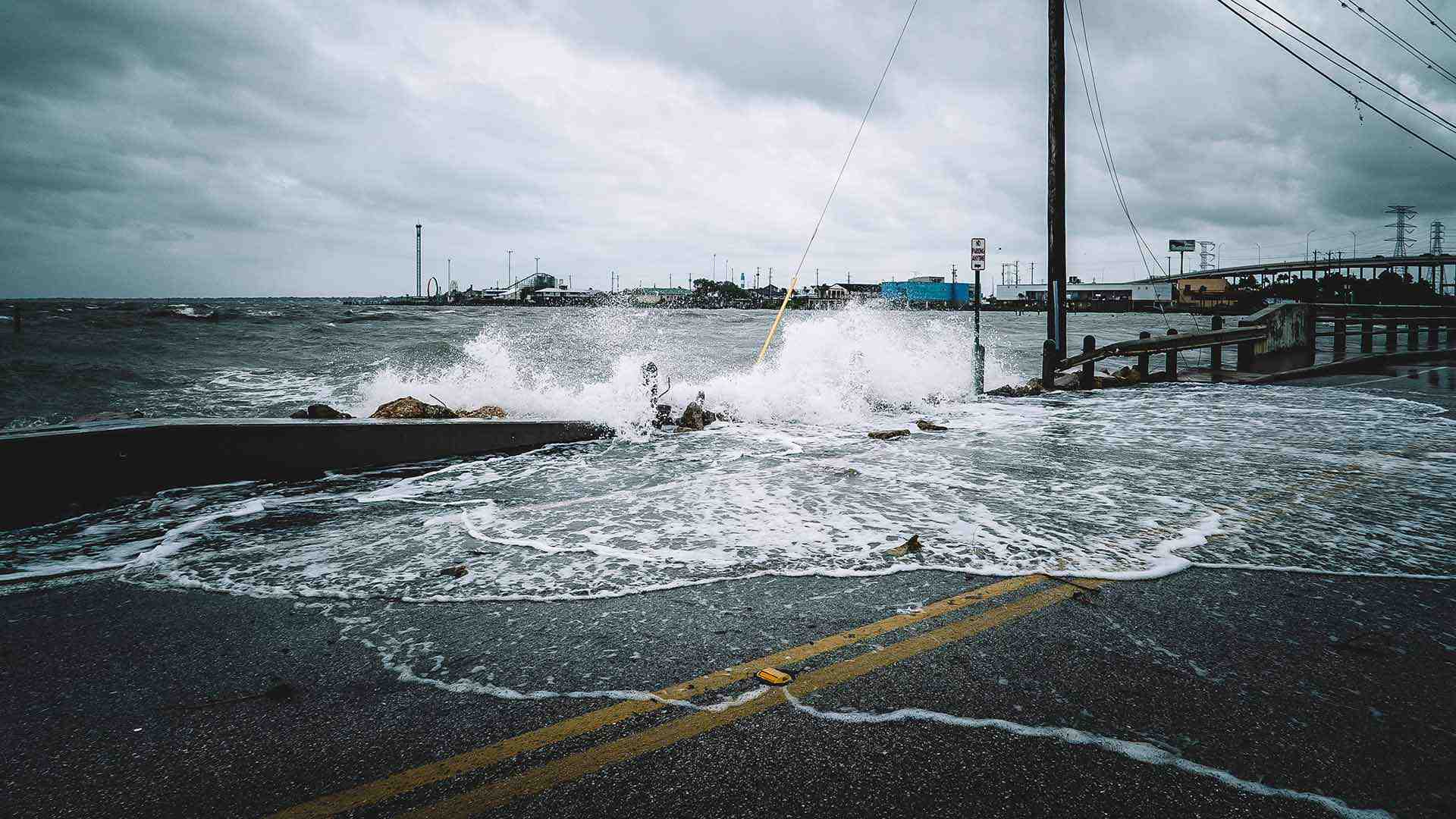 Water crashes over bridge during a storm in Kemah, Texas. Rising sea levels will threaten roads and infrastructure years before the communities they serve are inundated, new UMD research shows. Photo by iStock.